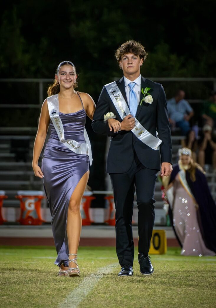 a couple of people that are walking on a field