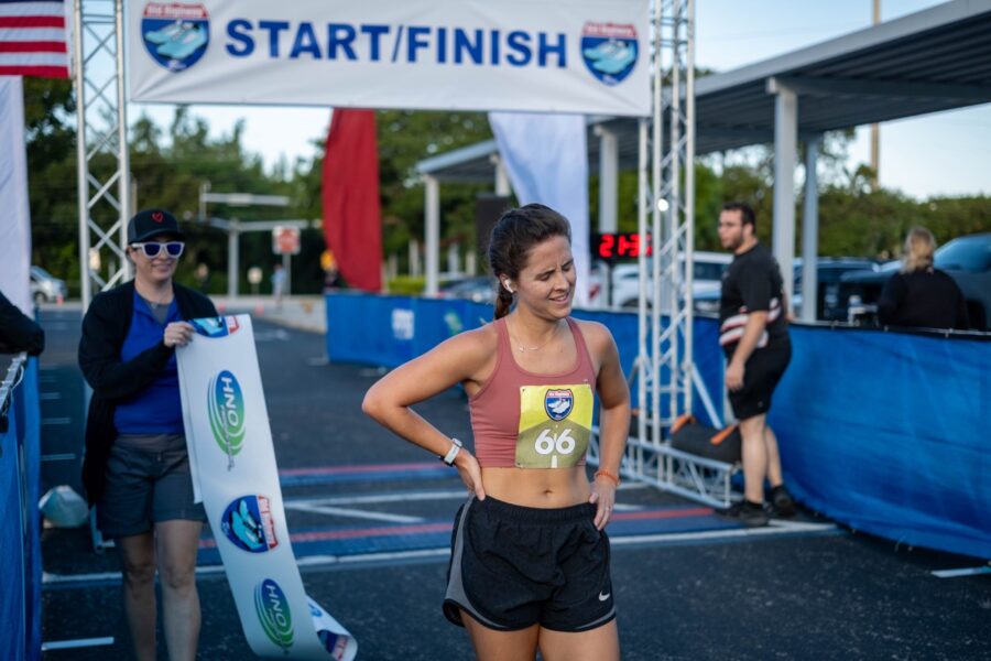 a woman in a sports bra standing in front of a finish line