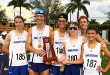 a group of young men standing next to each other holding a trophy