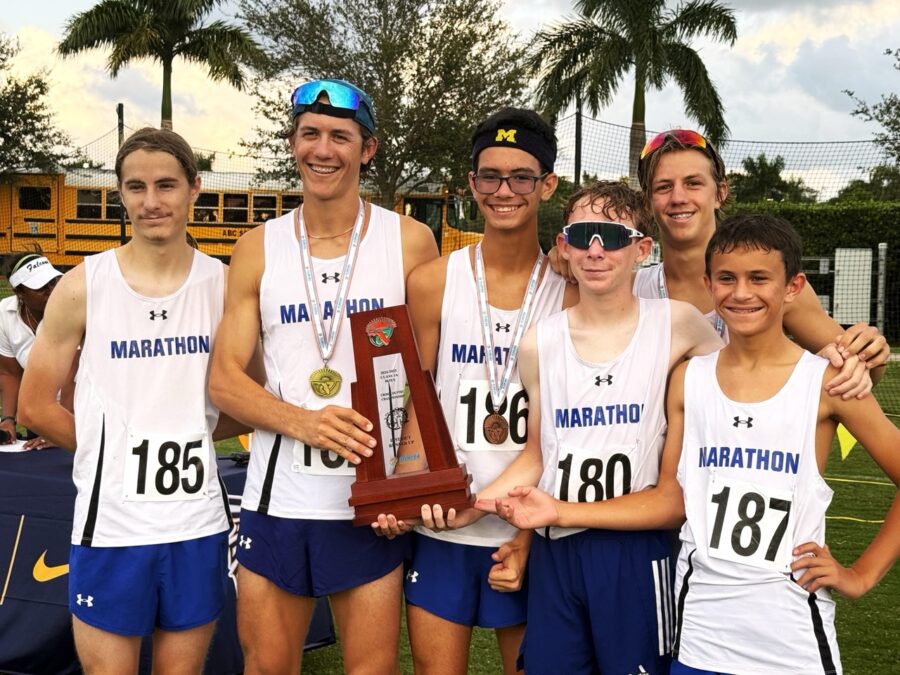 a group of young men standing next to each other holding a trophy