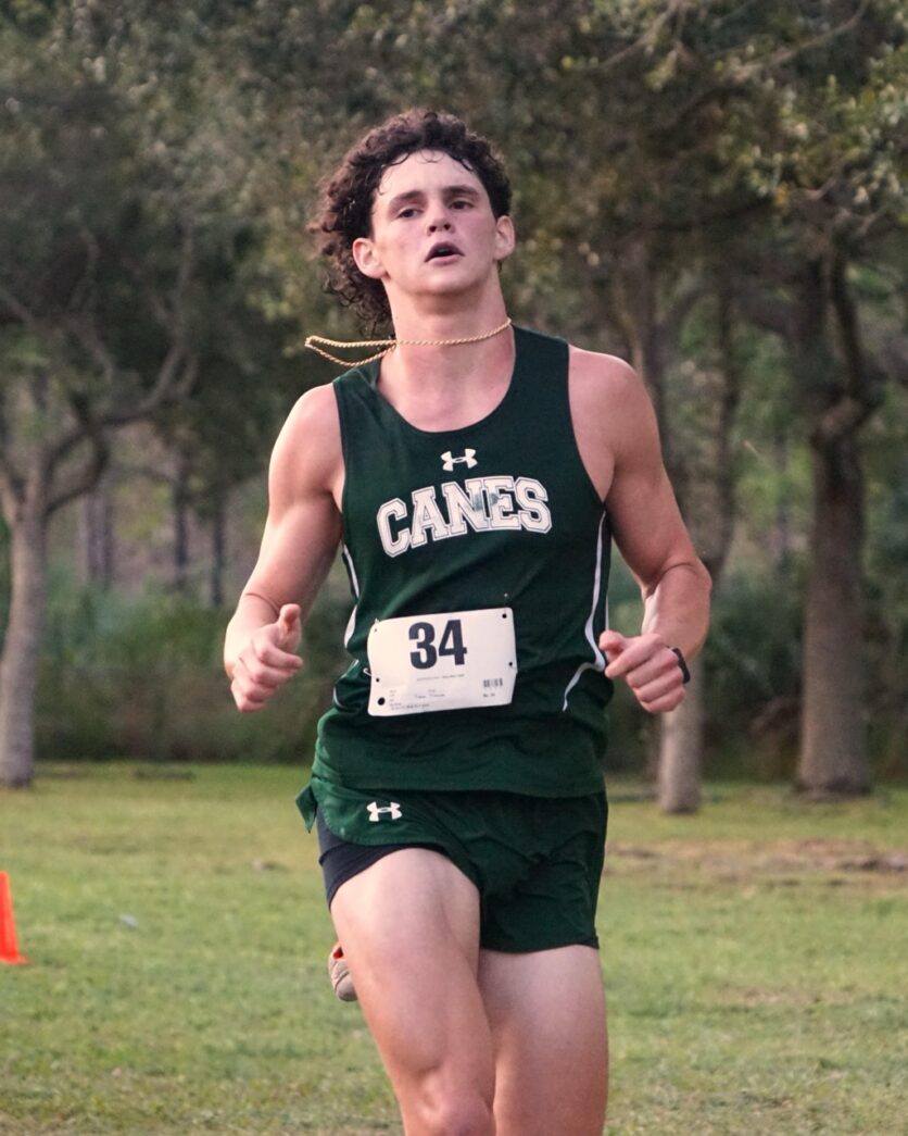 a man in a green uniform running in a race