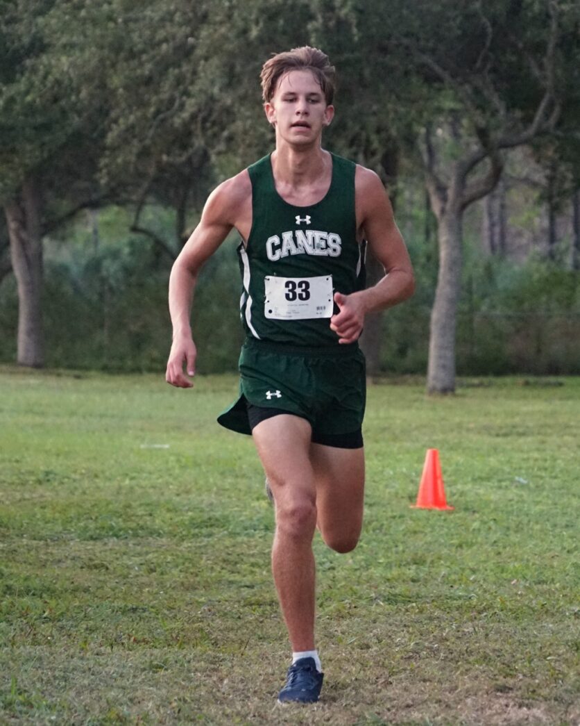 a man running in a race with trees in the background