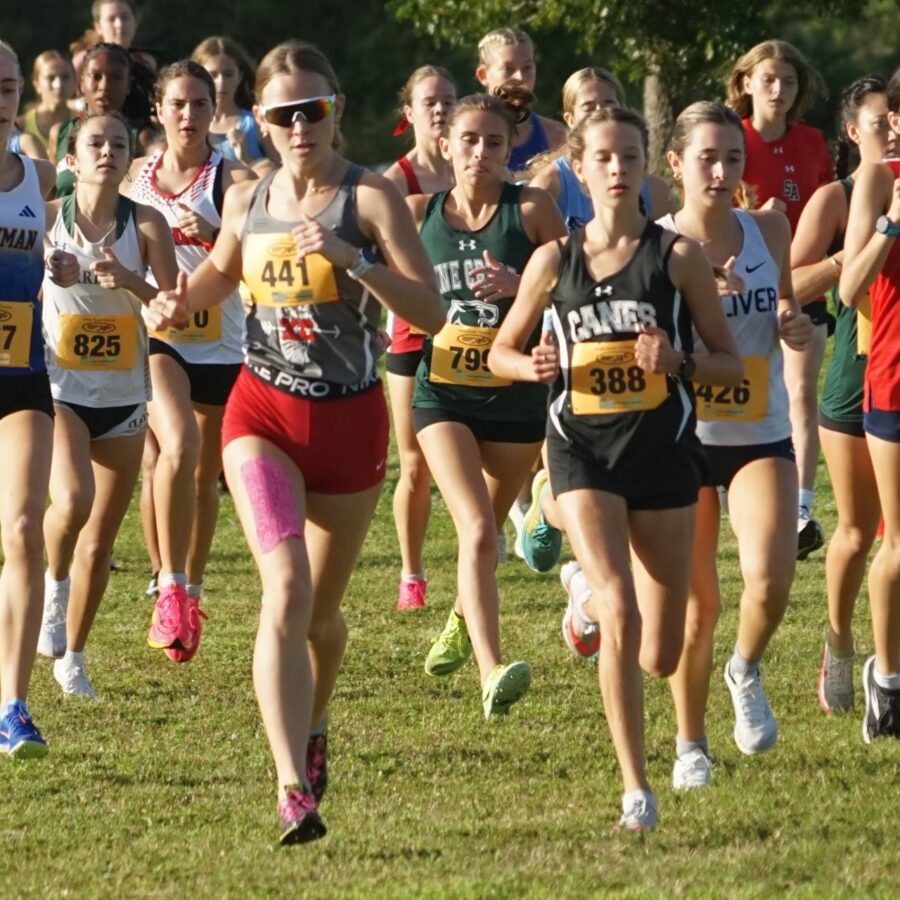 a group of girls running in a cross country race