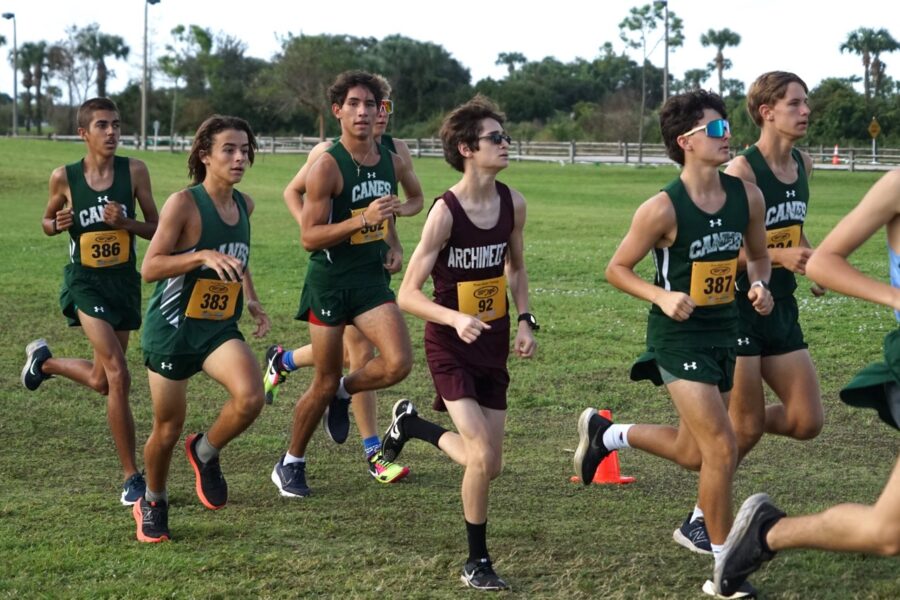 a group of young men running across a lush green field