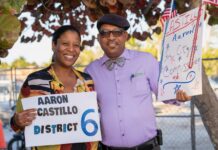 a couple of people standing next to each other holding signs