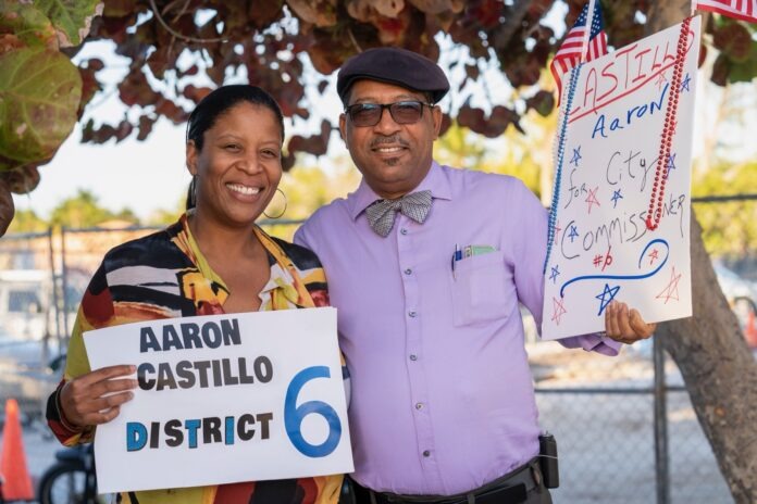 a couple of people standing next to each other holding signs