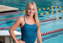 a woman standing next to a swimming pool