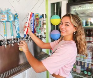 a woman is putting toothpaste on a toothbrush dispenser