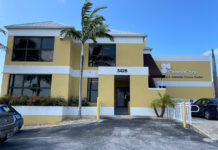 a yellow building with cars parked in front of it