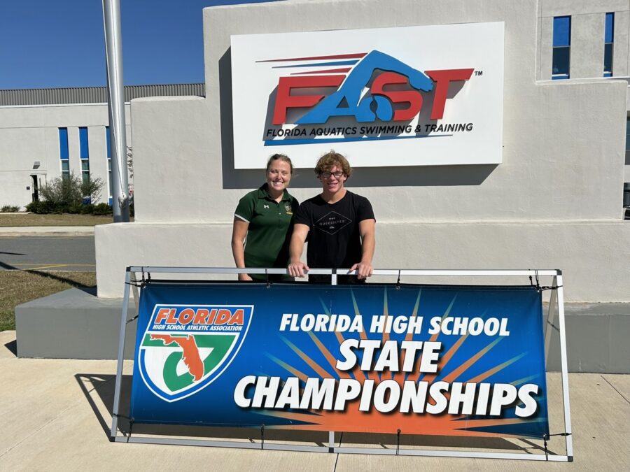 a couple of people standing in front of a sign