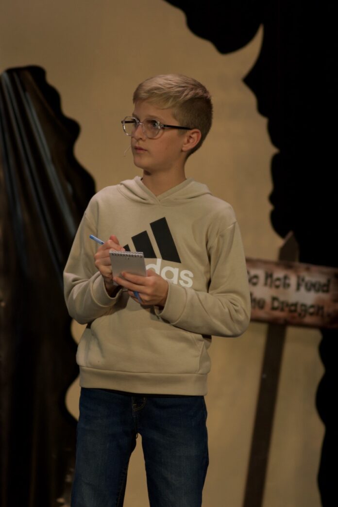 a young boy standing in front of a statue