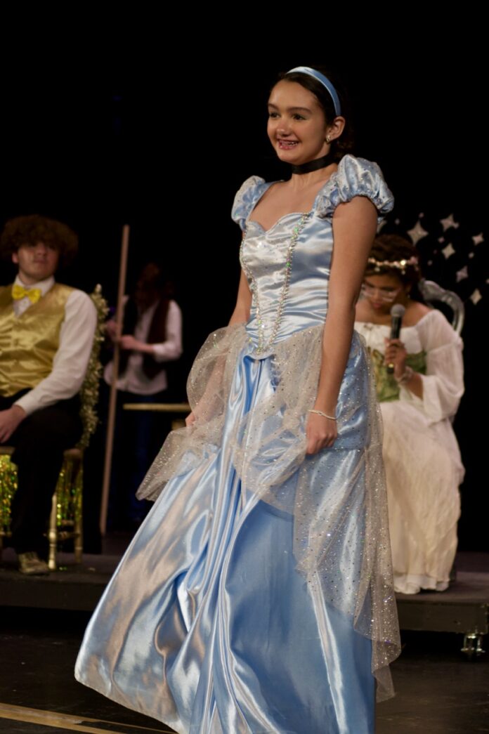 a woman in a blue dress walking down a runway