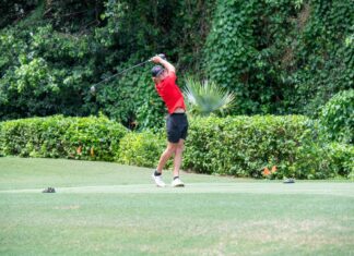 a man swinging a golf club on a golf course