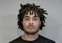 a mug shot of a man with dreadlocks