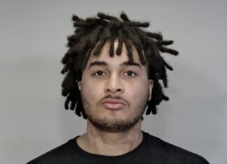 a mug shot of a man with dreadlocks