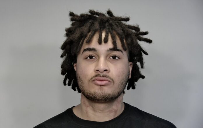 a mug shot of a man with dreadlocks