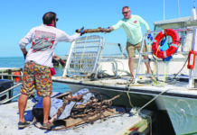 a couple of men standing on top of a boat