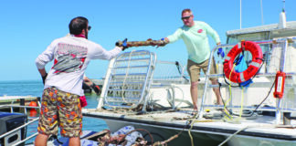 a couple of men standing on top of a boat