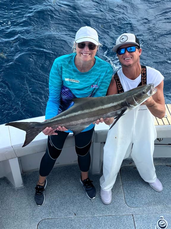 a couple of people on a boat with a fish