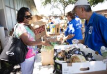 a man and a woman standing next to boxes of food