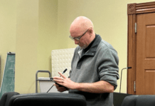 a man standing in front of a podium holding a cell phone