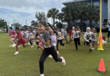 a group of children running around a field