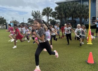 a group of children running around a field