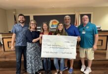 a group of people holding a large check