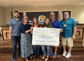 a group of people holding a large check