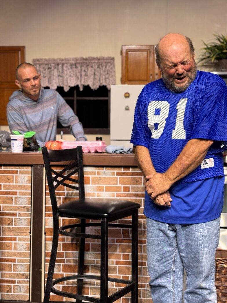 a man standing in a kitchen next to a bar