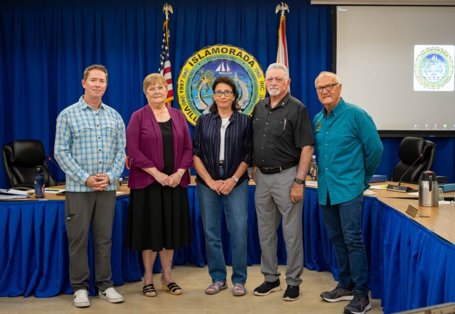 a group of people standing in front of a blue curtain