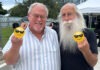 a man with a long white beard and a long white beard holding two yellow smiley