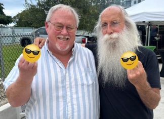 a man with a long white beard and a long white beard holding two yellow smiley