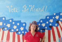 a woman standing in front of a painting of an eagle