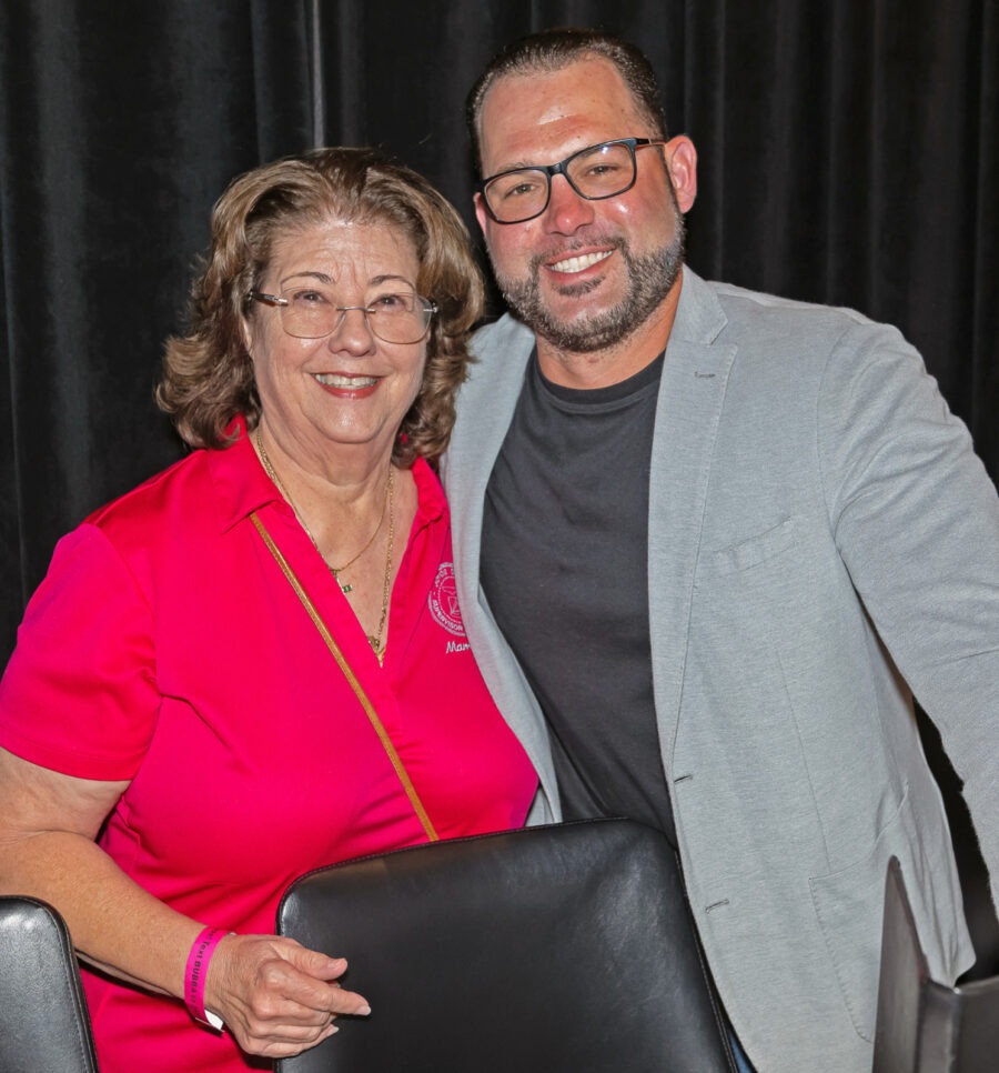 a man standing next to a woman holding a chair