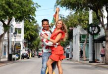 a man and a woman dancing on a rainbow painted street