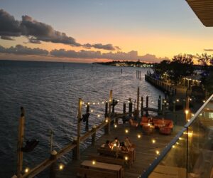 a restaurant with a view of the water at sunset