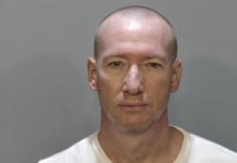 a mug shot of a man in a white shirt