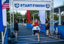 a man running in a marathon under a start finish sign