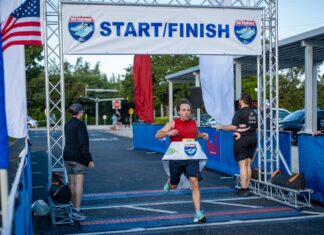 a man running in a marathon under a start finish sign