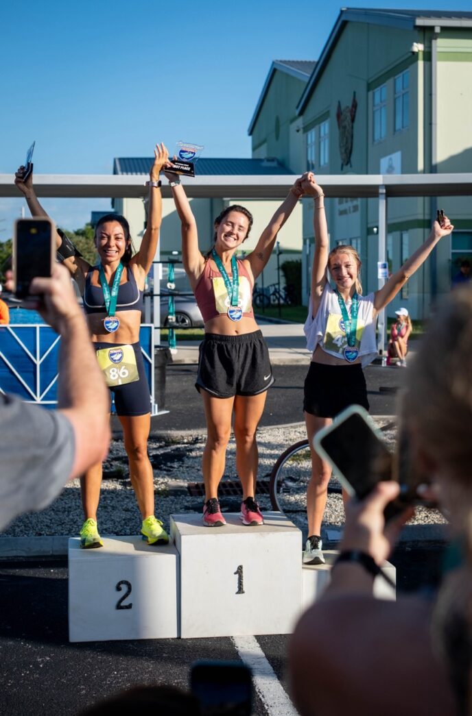 a group of women standing on top of a winners podium