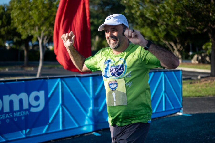 a man in a green shirt running in a marathon