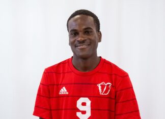 a man in a red shirt is posing for a picture