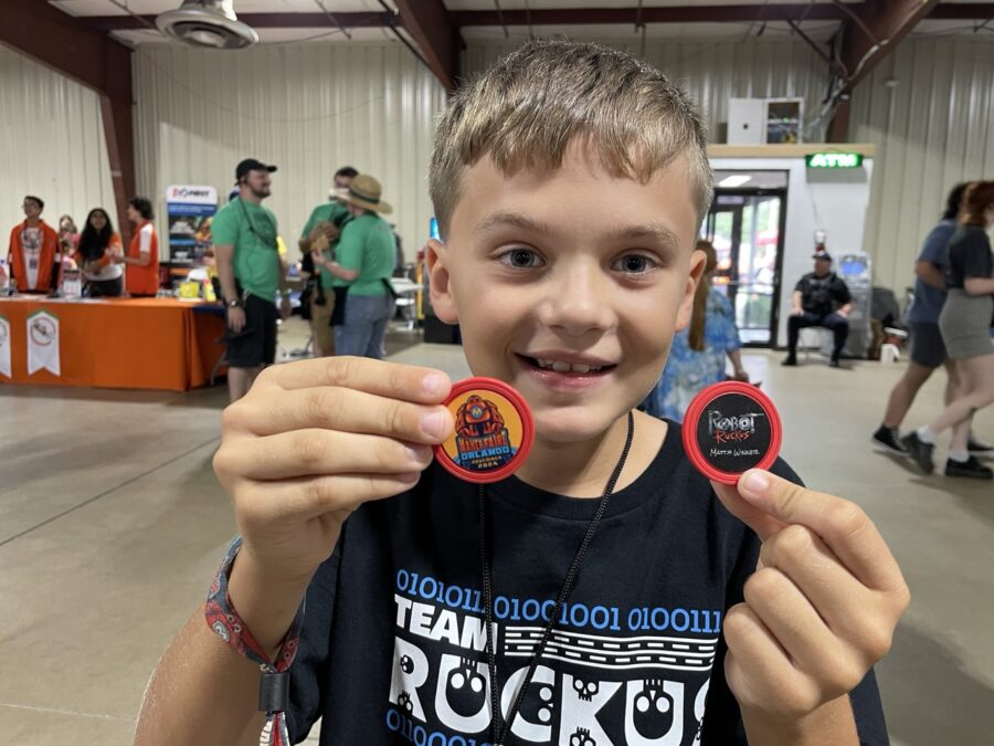 a young boy holding two badges in front of his face