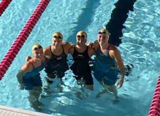 a group of women standing next to each other in a swimming pool