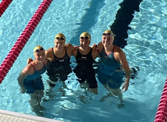 a group of women standing next to each other in a swimming pool