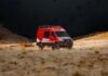 a red van is parked in the desert