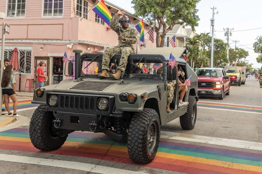 a military jeep driving down a street next to a building