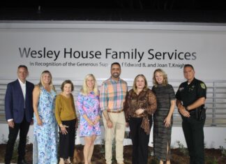 a group of people standing in front of a sign