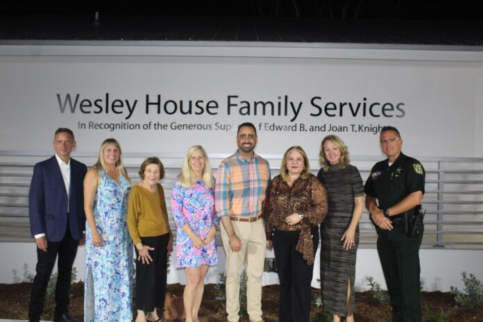 a group of people standing in front of a sign